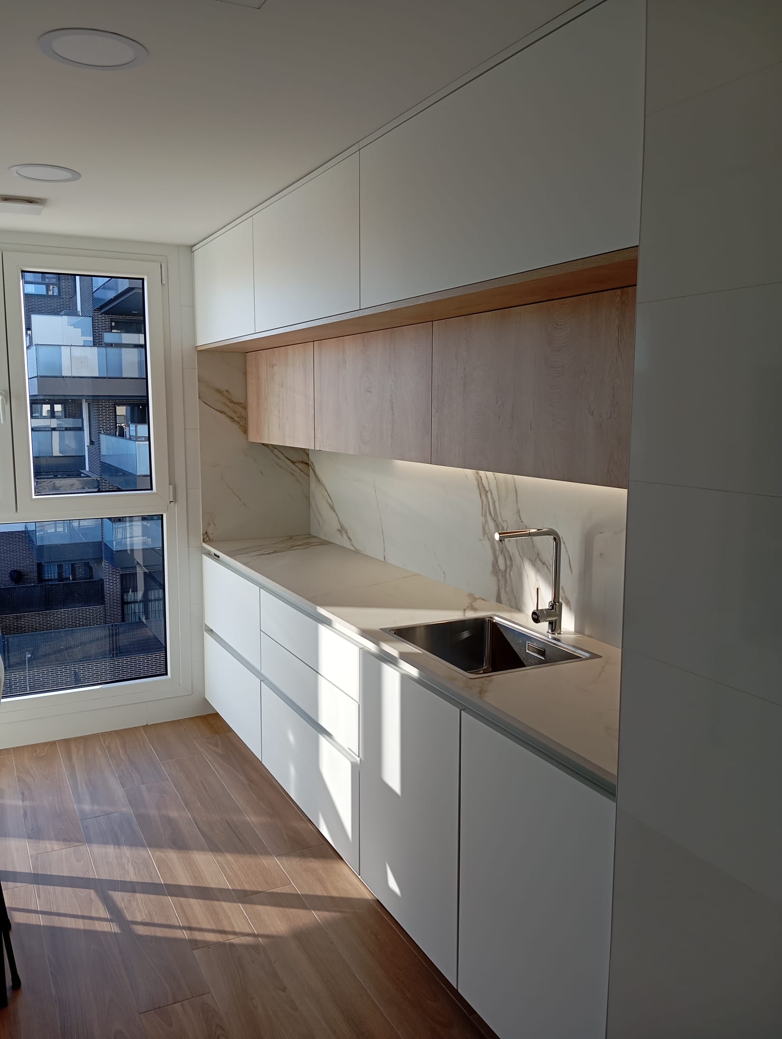 Cocina lineal minimalista en Calacatta Gold
