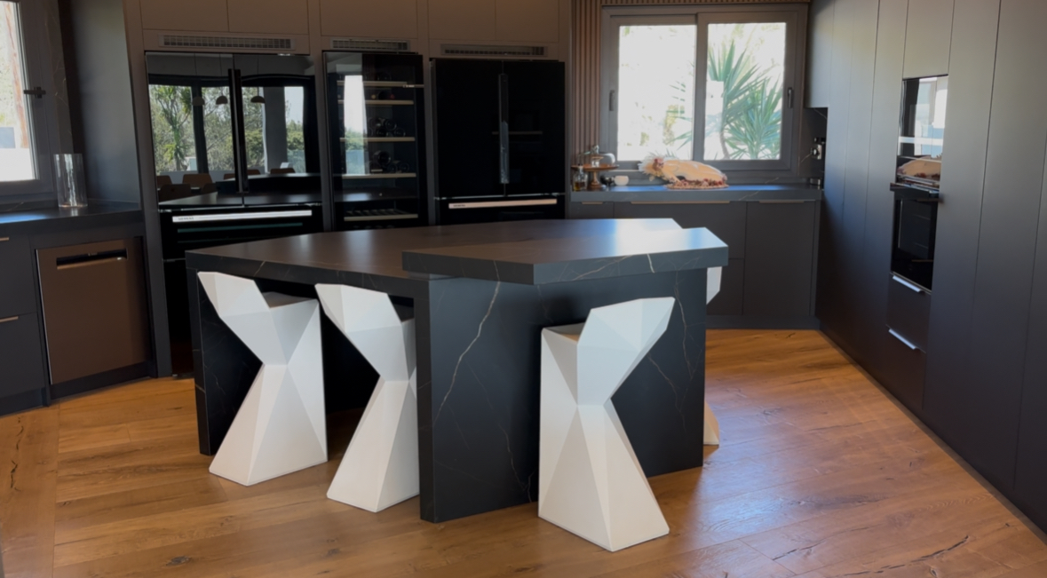 Cocina integrada en el salón con isla en doble altura Marquina Gold